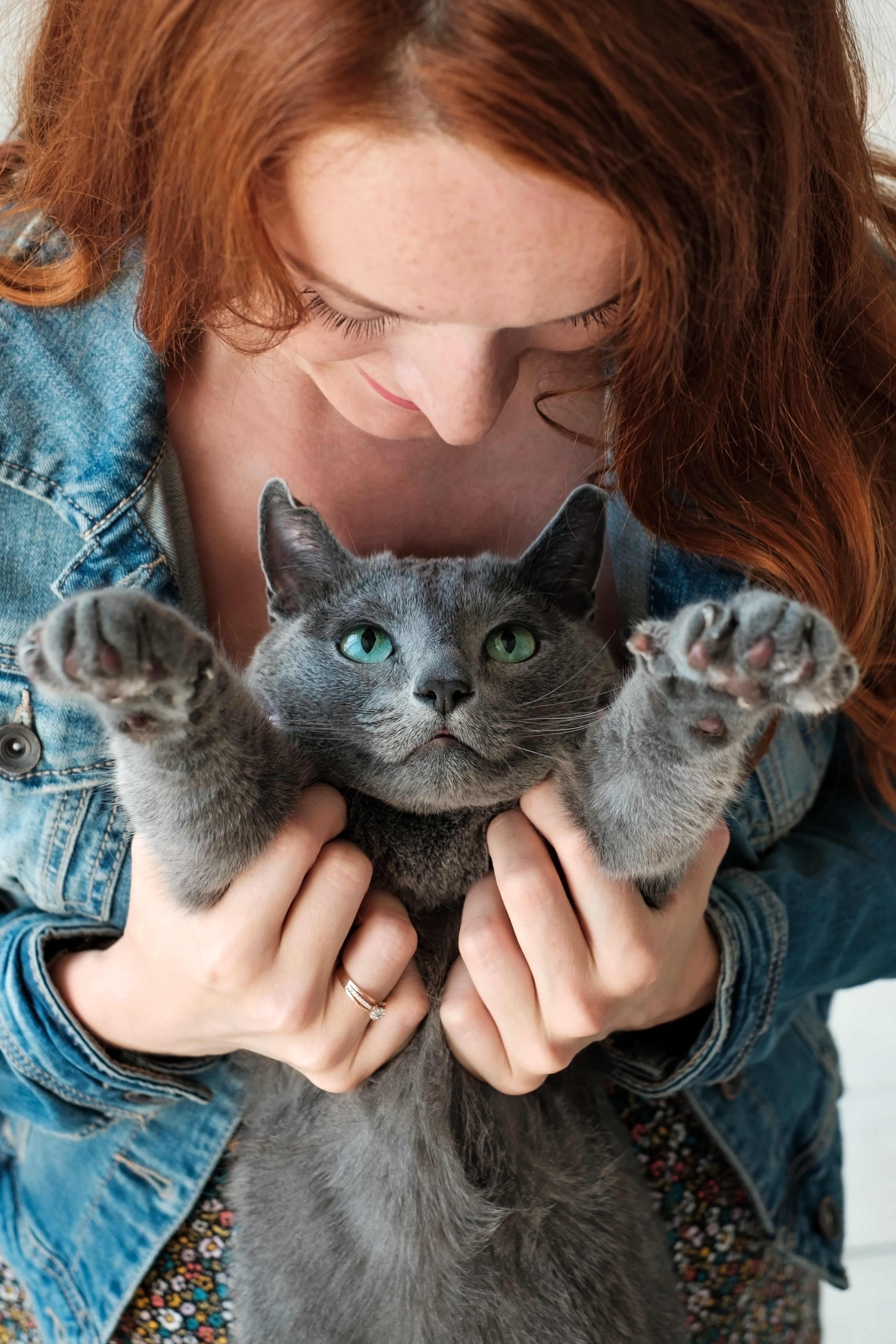 cheerful-redhead-girl-plays-with-her-blue-cat